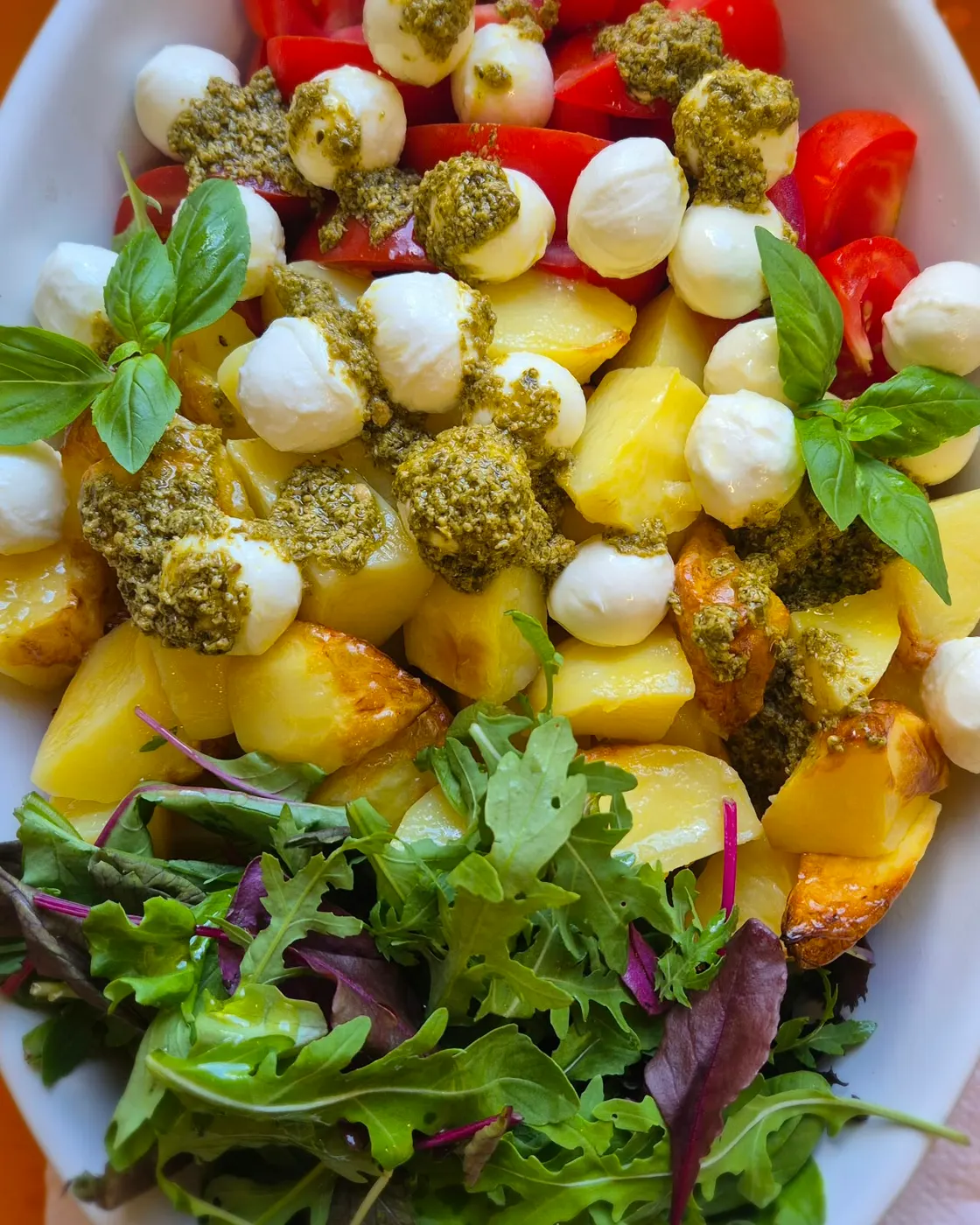 Potato salad with mozzarella, tomatoes, pesto and rocket