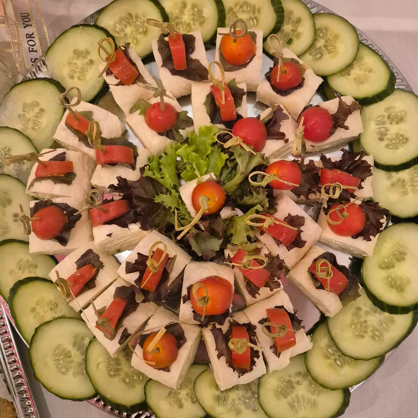 Small canapés with tomato on a platter with cucumber slices