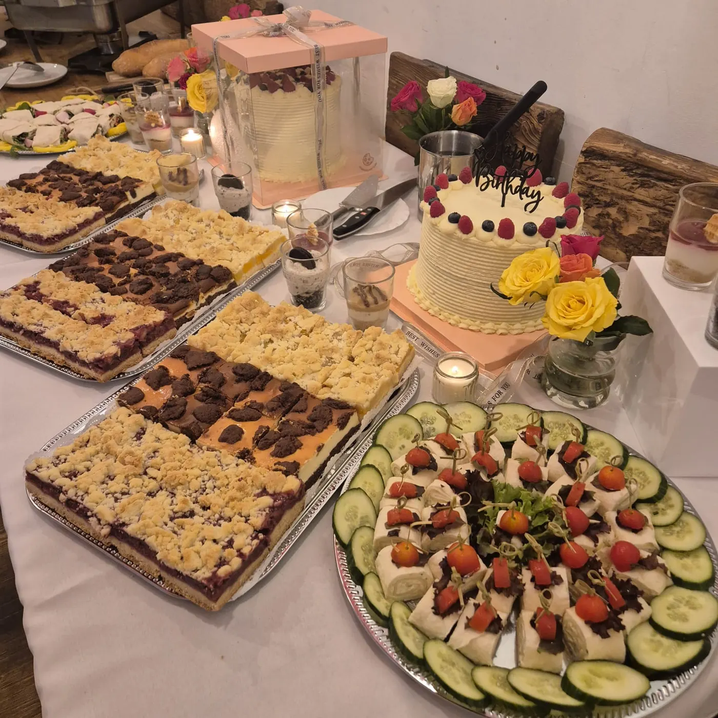 Cake buffet with sheet cakes, a birthday cake and canapés