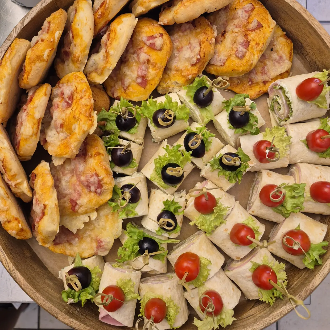 Platter with wrap bites and small pizza rolls