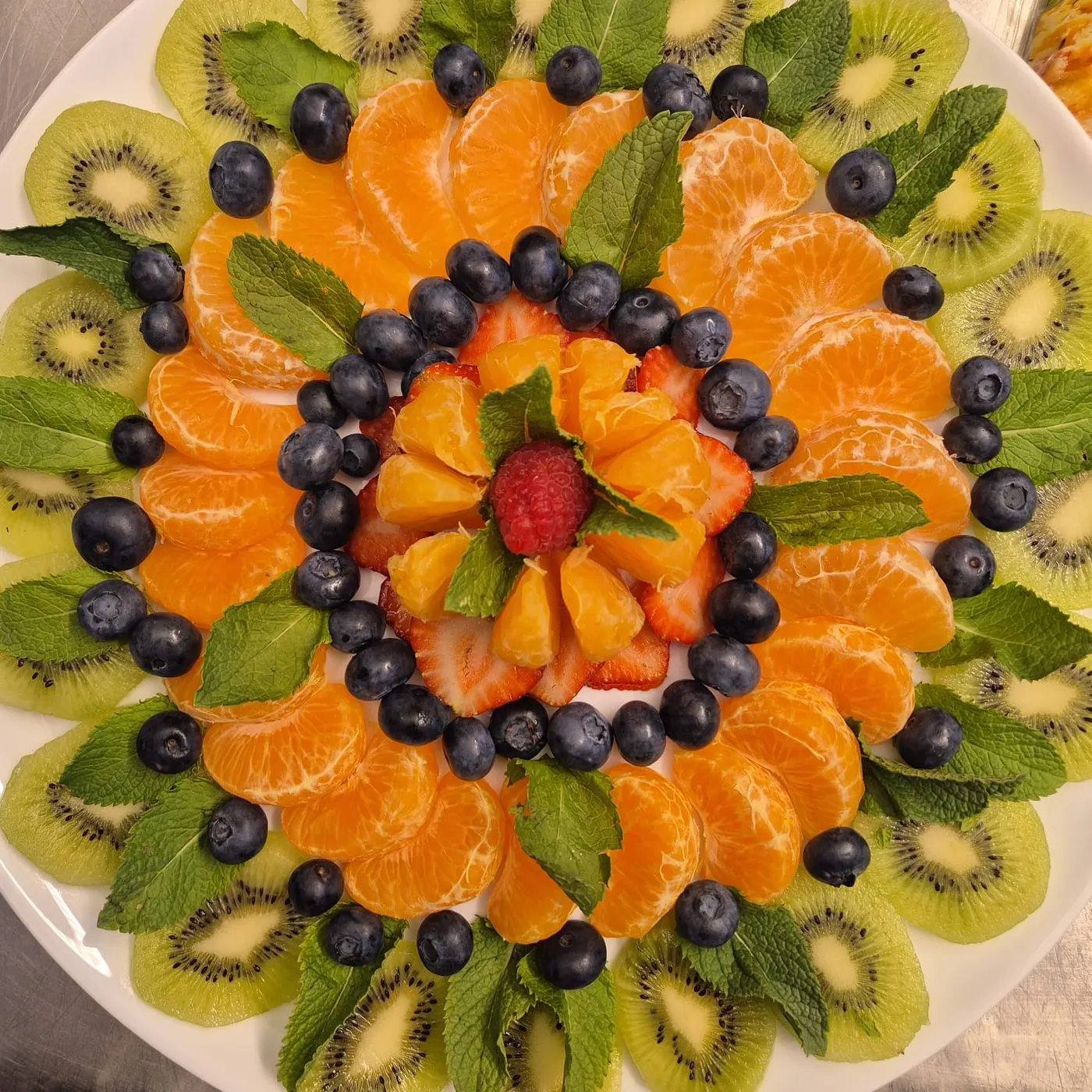 Fruit platter with kiwi, mandarins, blueberries and a strawberry