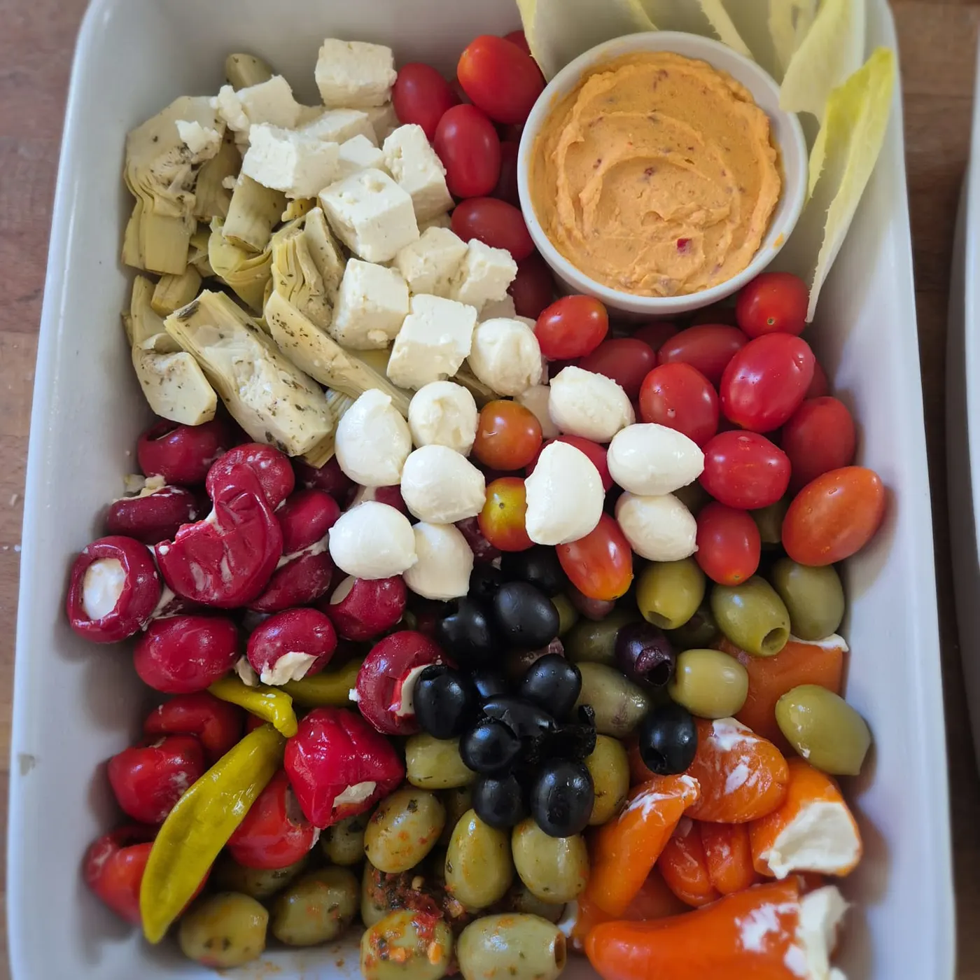 Antipasti platter with olives, feta, mozzarella, stuffed peppers and dip