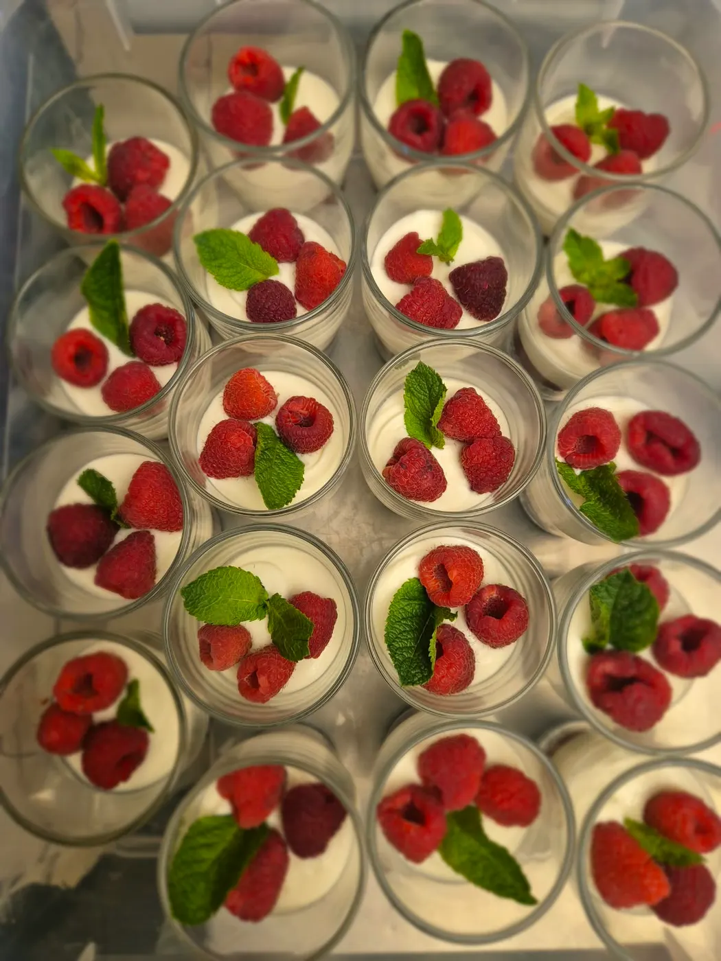 Dessert glasses with cream, raspberries and mint