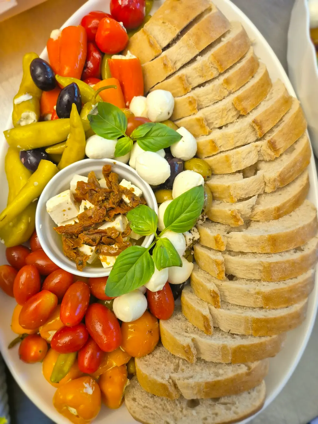 Antipasti platter with baguette, tomatoes, mozzarella and peppers