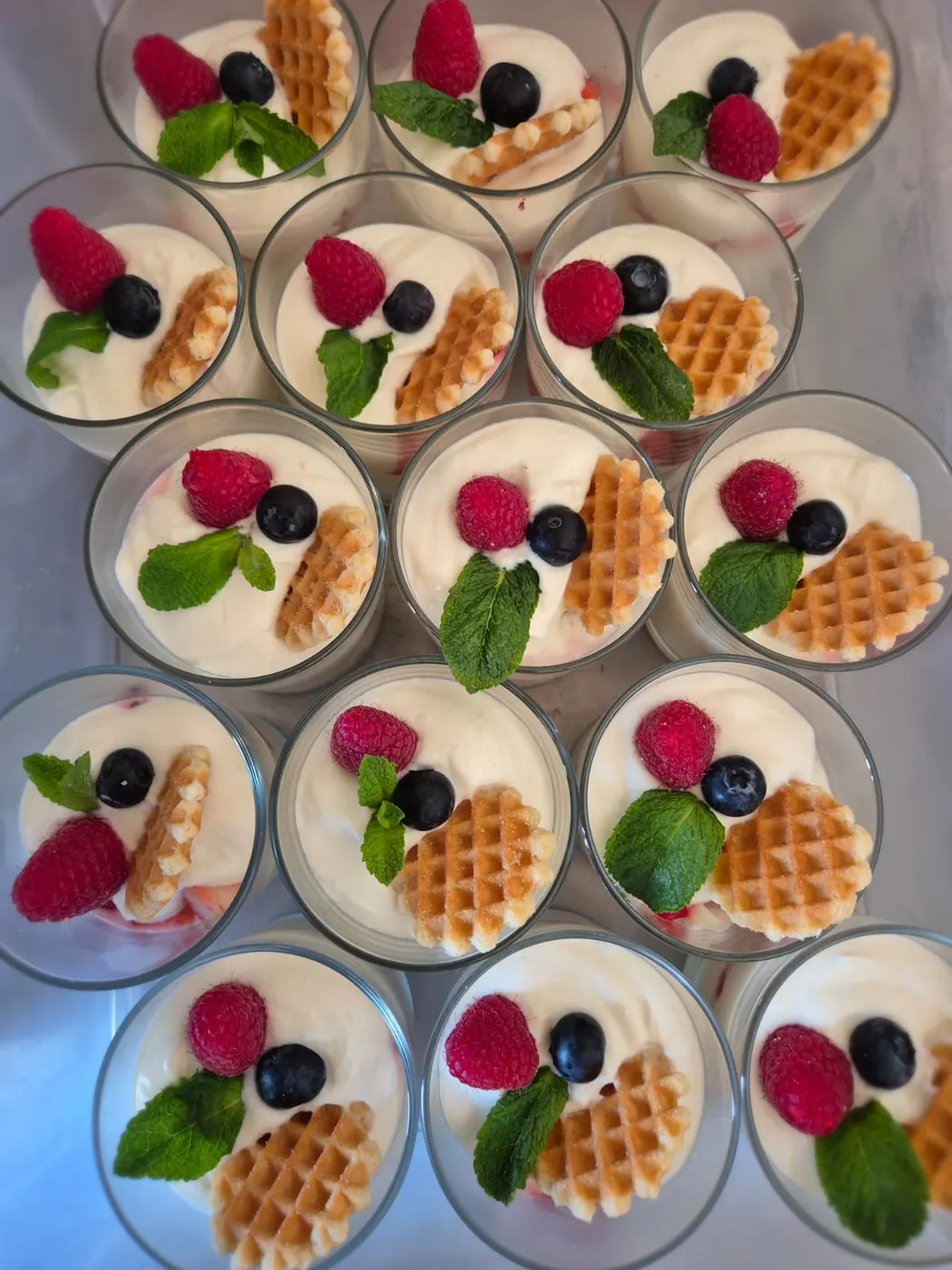Dessert glasses with cream, berries and small waffles