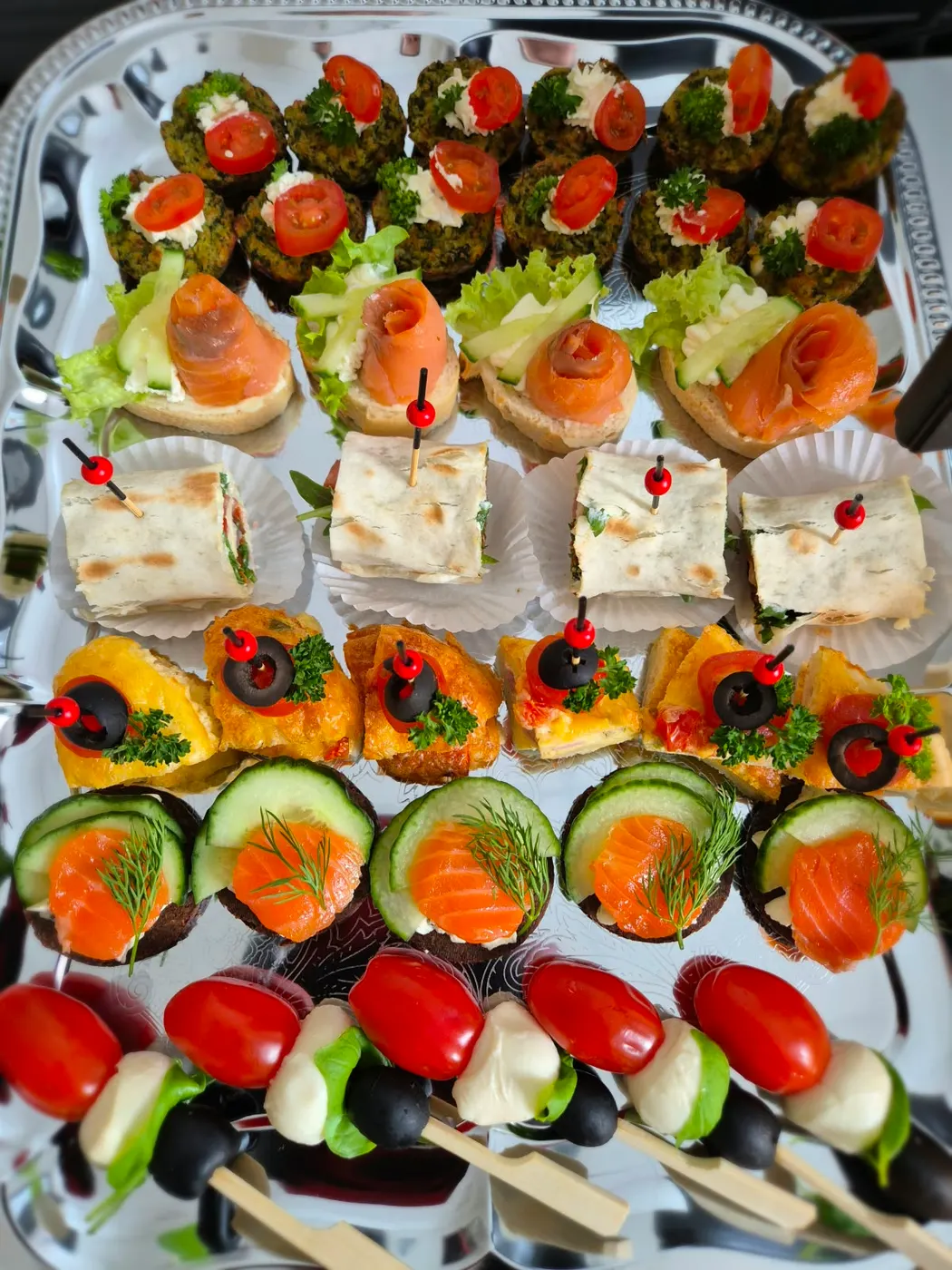 Finger food platter with salmon bites, wraps and tomato mozzarella skewers
