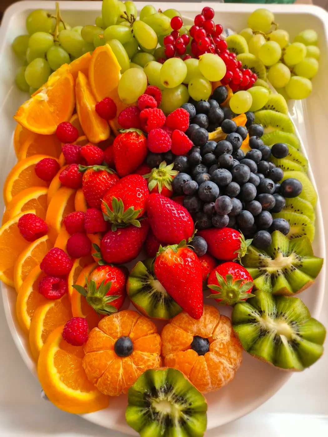 Fruit platter with strawberries, blueberries, kiwi and oranges